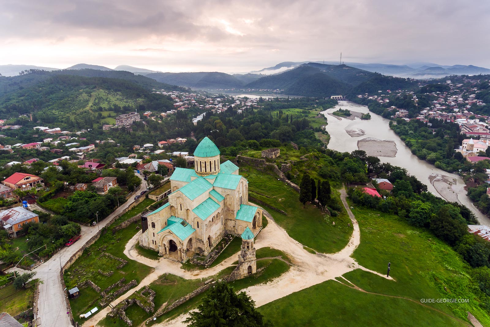 Vue aérienne de la cathédrale Bagrati à Kutaisi, coupole et murs en pierre entourés de bâtiments et d'espaces verts