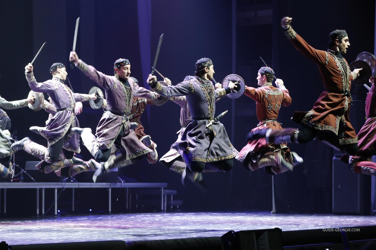 Groupe de danseurs en costumes traditionnels géorgiens sur scène lors d'un spectacle