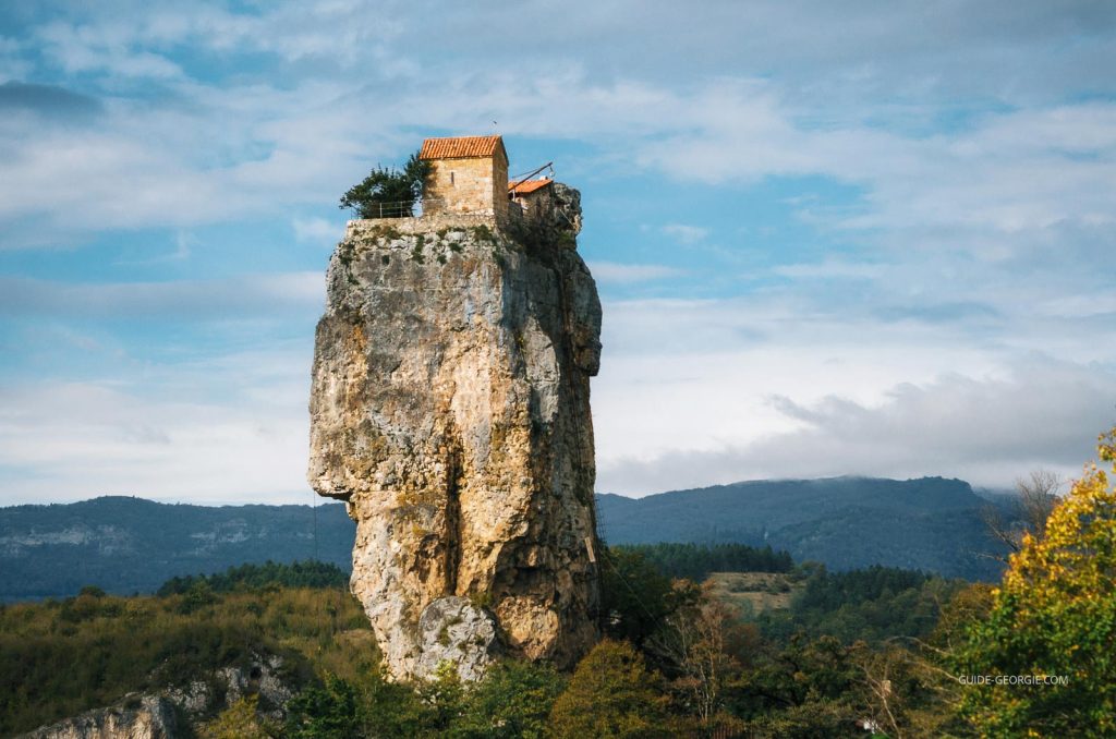 Pilier rocheux isolé avec une petite église orthodoxe et une cellule d'ermite au sommet sous un ciel nuageux
