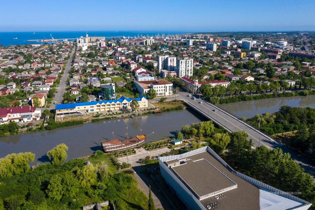 Panorama aérien montrant une ville côtière avec bâtiments, maisons et littoral depuis un drone