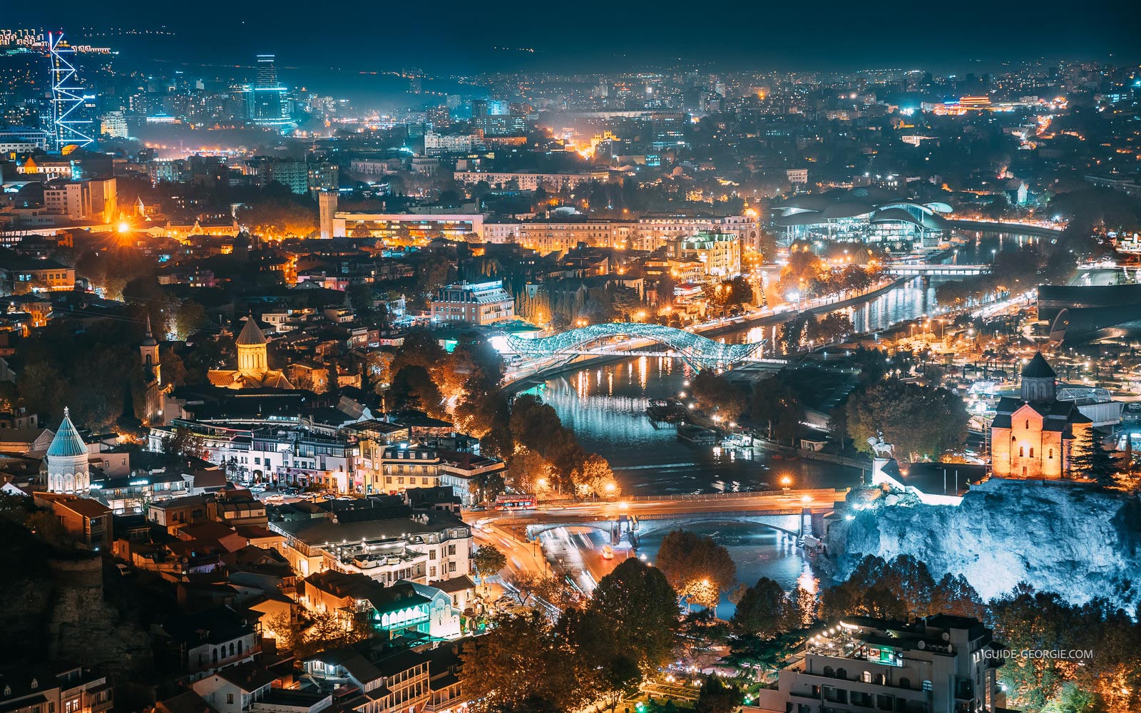 Vue aérienne nocturne du paysage urbain de Tbilissi avec illuminations et silhouettes de bâtiments